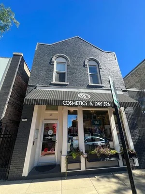 Two-story brick storefront with freshly painted exterior, white trim, and arched windows