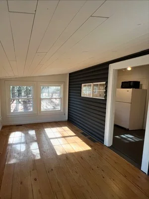 White painted ceiling and walls with black shiplap accent wall, white trim, and hardwood floors