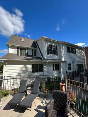 Two-story white house with gray roof, painted siding and trim, metal deck railing