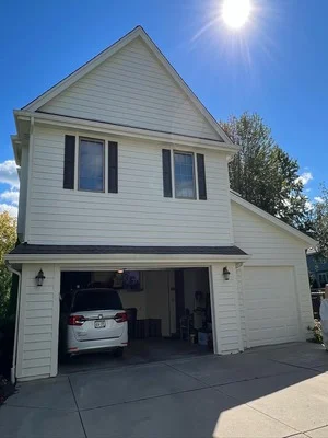 Two-story white painted house with garage, horizontal siding and trim